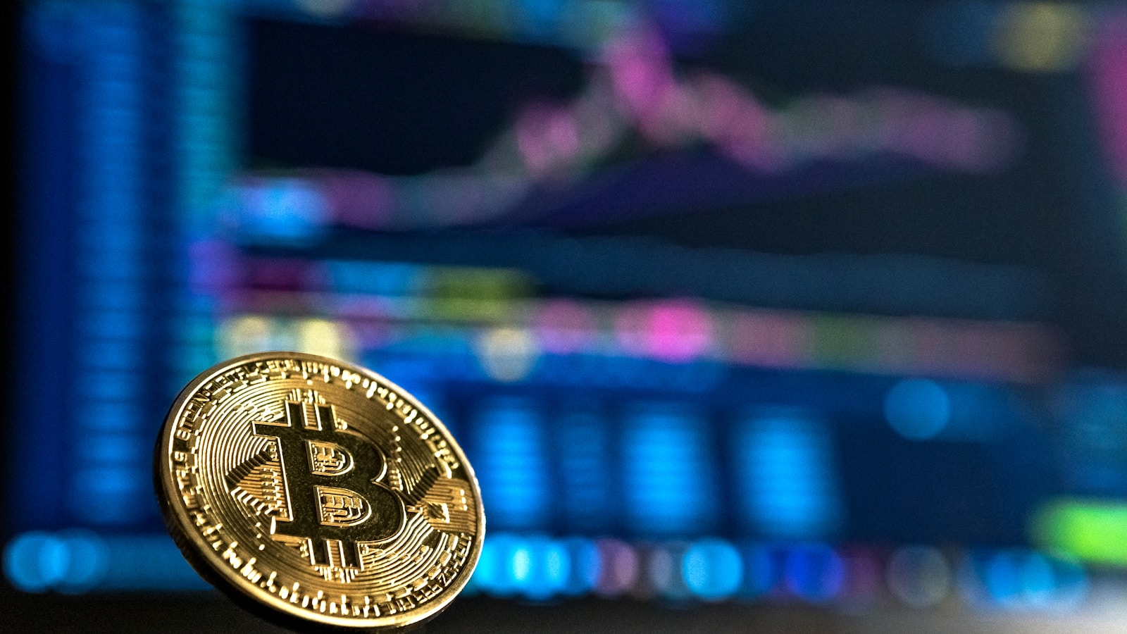 Bitcoin and ethereum coins on a laptop displaying a price chart