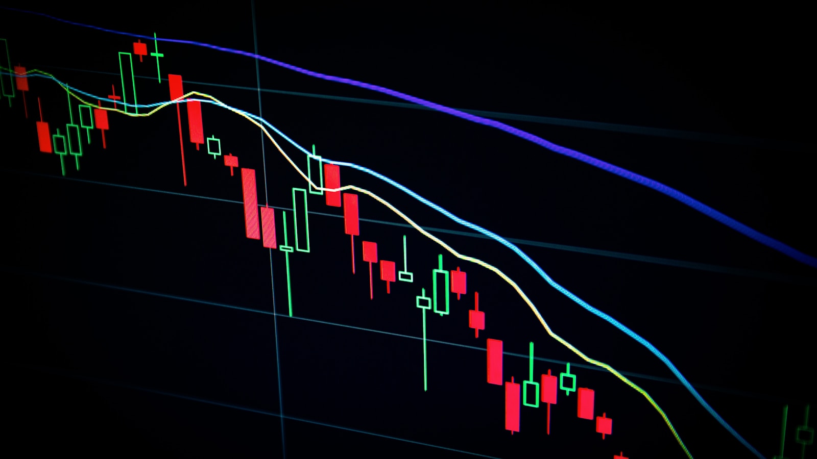 Stock market chart on a laptop with notebook and pen
