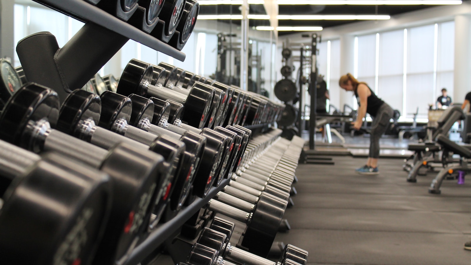 Person training with a barbell in a clean modern gym