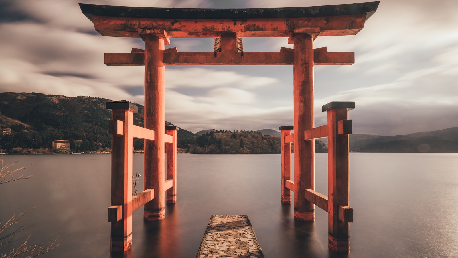 Mount Fuji and cherry blossoms reflected in calm water at dawn