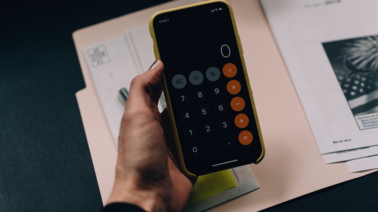 Freelancer working on invoices at a wooden desk with a calculator