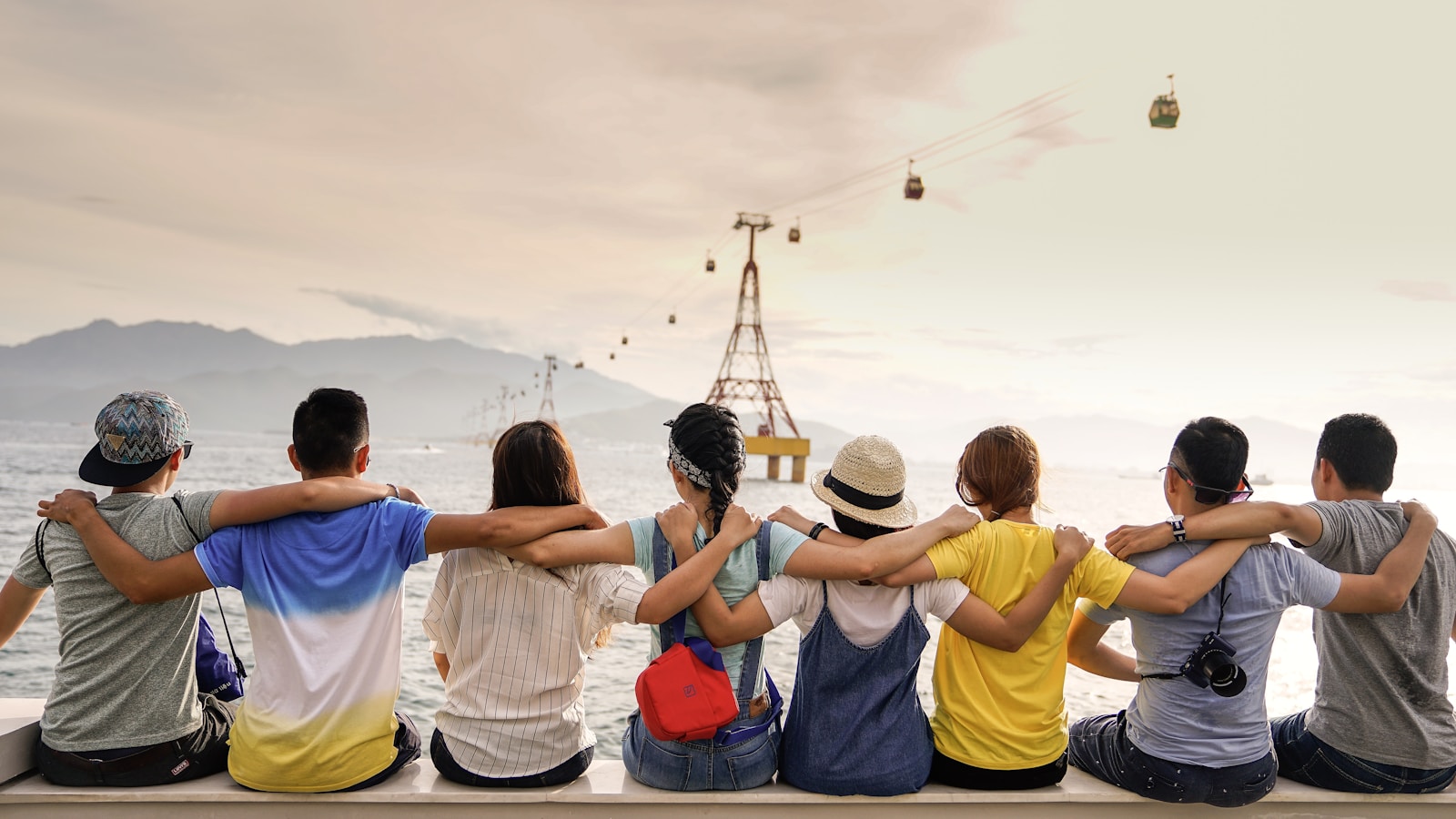 Group of friends laughing together at a casual outdoor cafe table