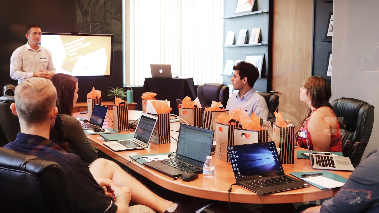 Small team meeting around a conference table with sticky notes on a wall