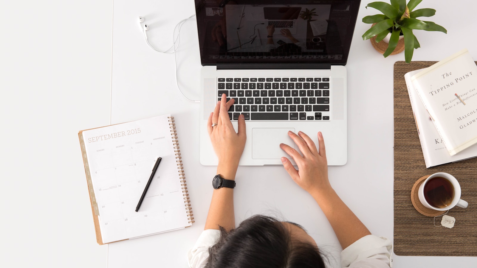 Printed CV next to a laptop and a hot drink at a tidy desk