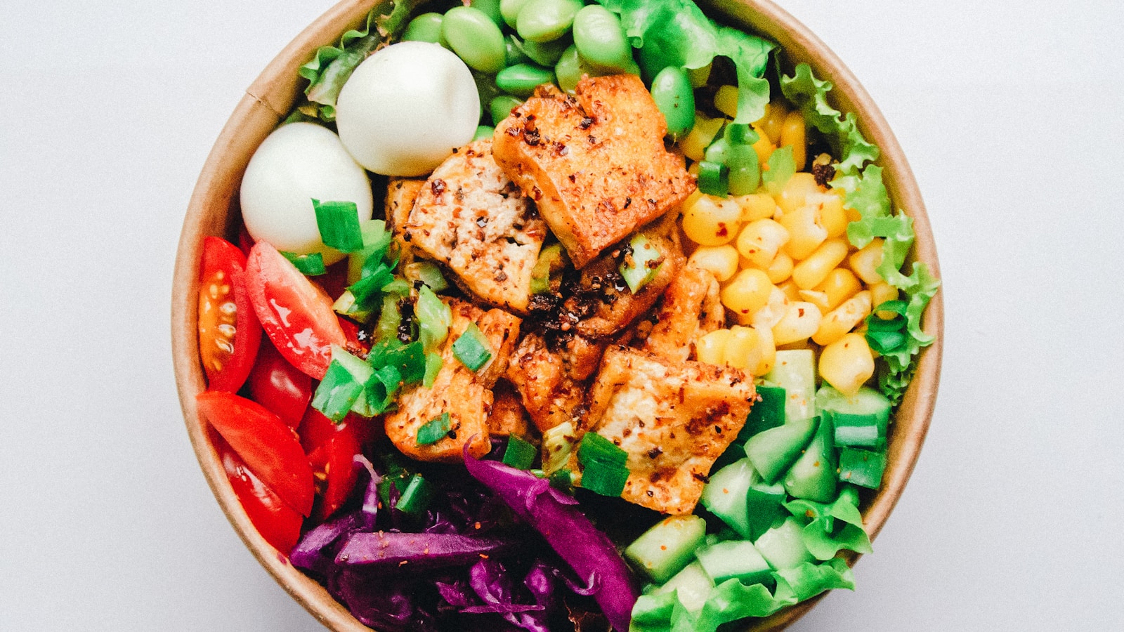 Glass meal prep containers with cooked vegetables, grains and protein